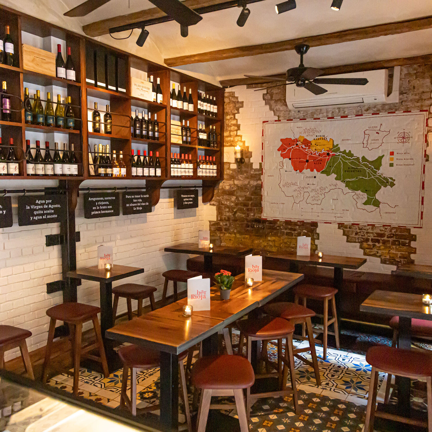 Internal shot of Bar Rioja showing a deep brown shelf with wine and a map of Rioja on the back wall.
